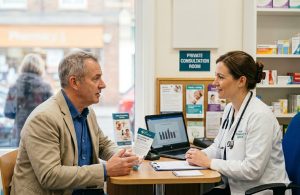 Man in a private consultation with a pharmacist at Ham Pharmacy Group discussing a sensitive men's health concern.